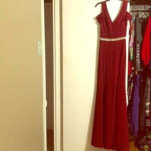 Maroon floor length dress with leg slit.
